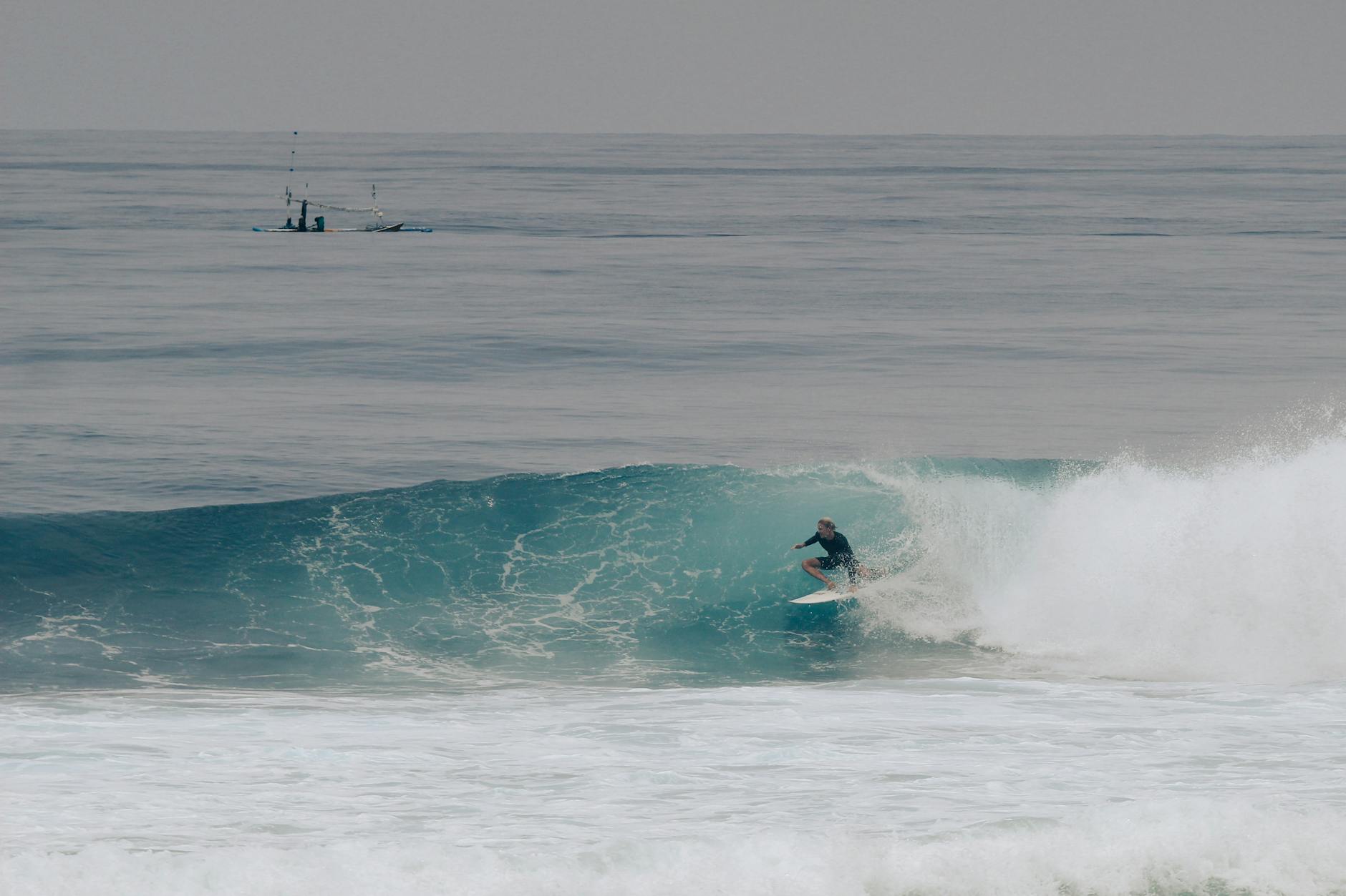 Surfer riding a wave at Uluwatu, Bali