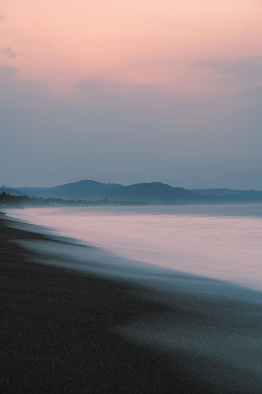 Soft sunset over the black sand beach in Lovina, Bali