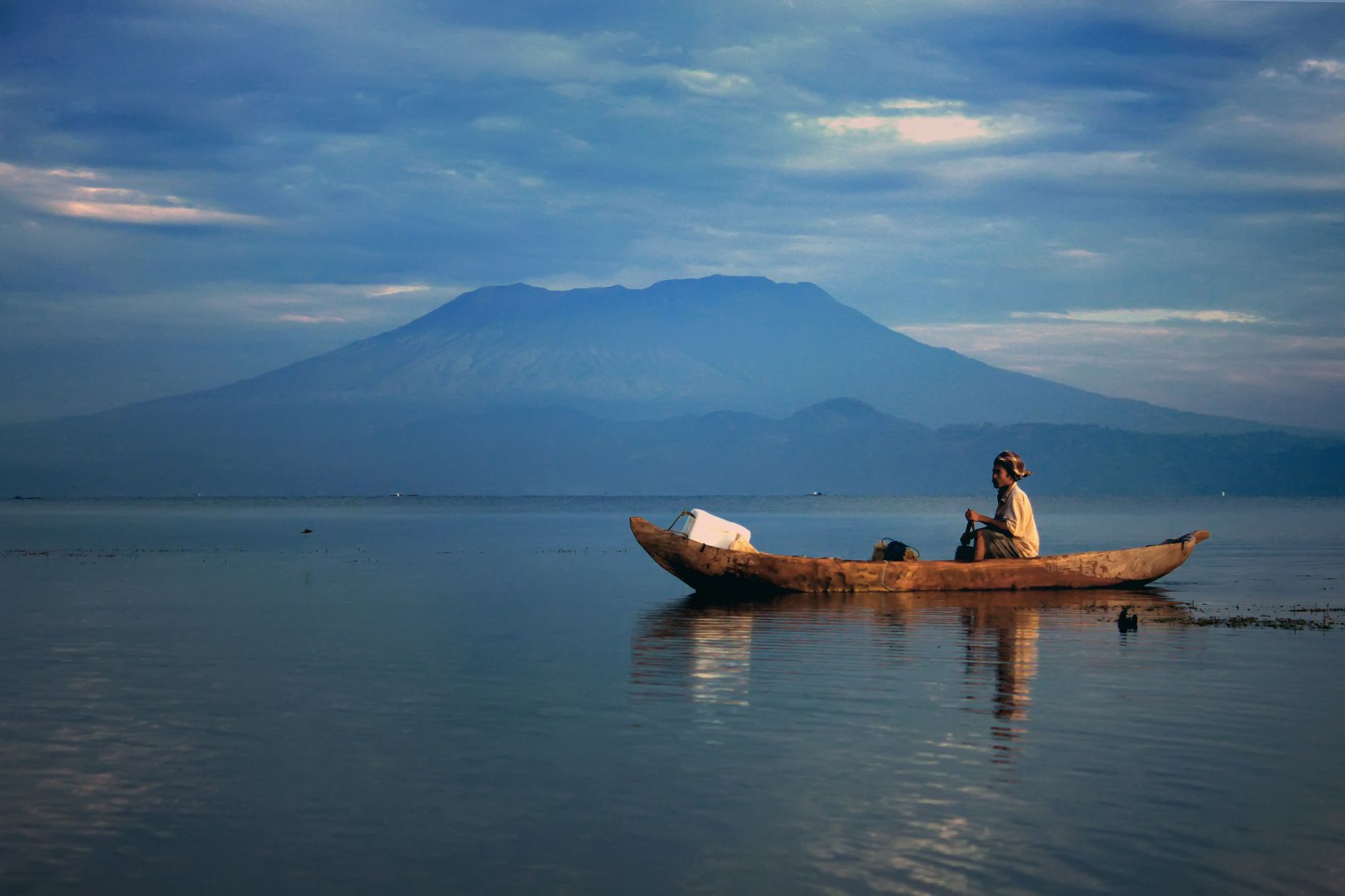 Traditional boat on calm water with mountain views in Lovina, North Bali