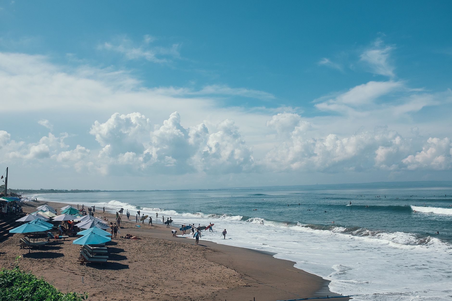Surfers walking along the beach in Canggu, Bali