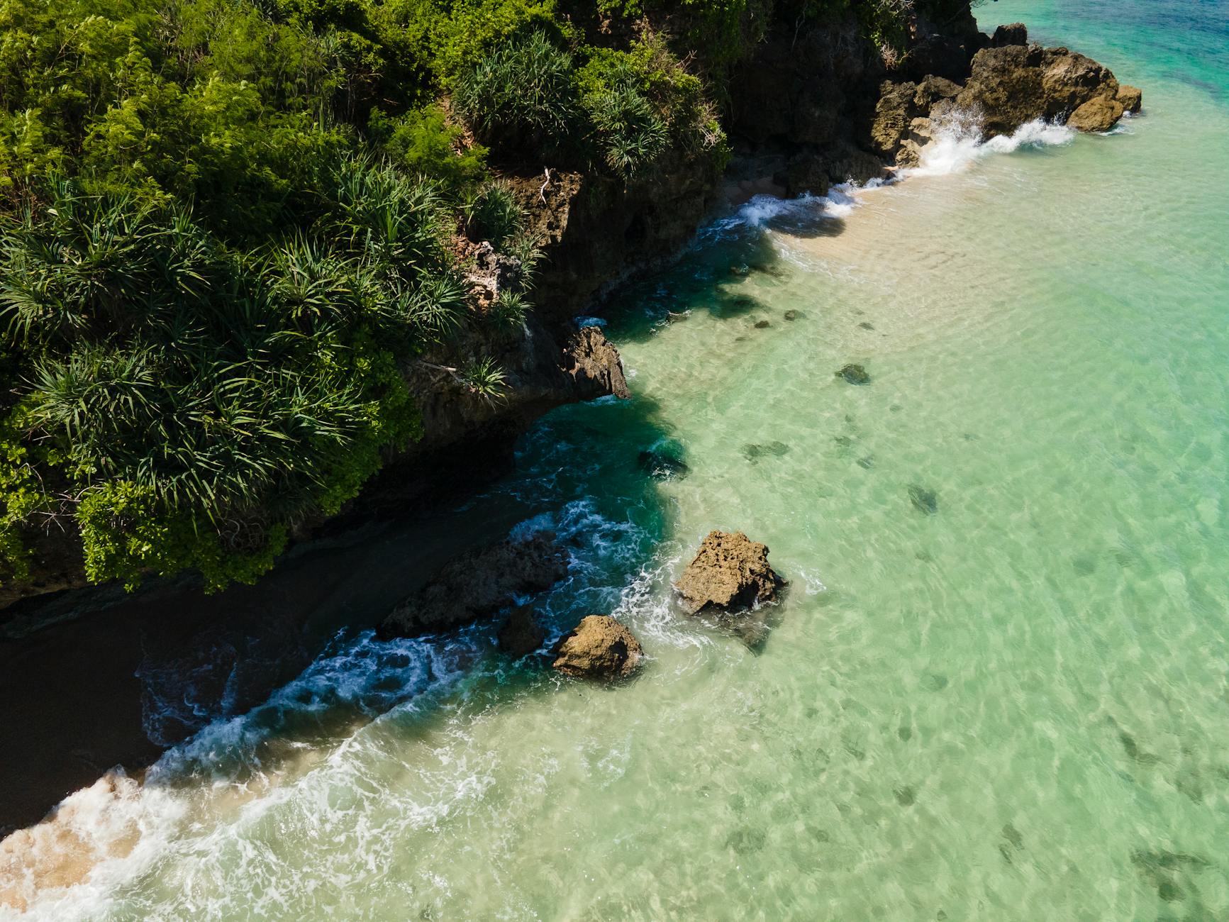 Aerial view of turquoise water and cliffs along the Uluwatu coastline