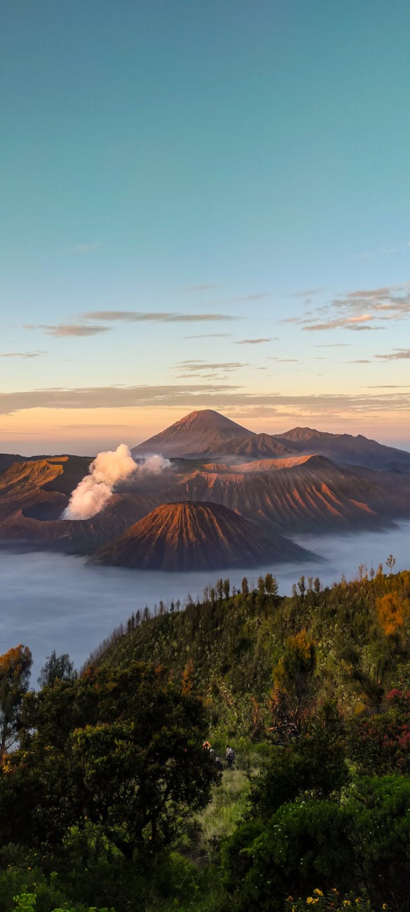 Mount Bromo sunrise view in Java with smoking volcano crater and mountain landscape
