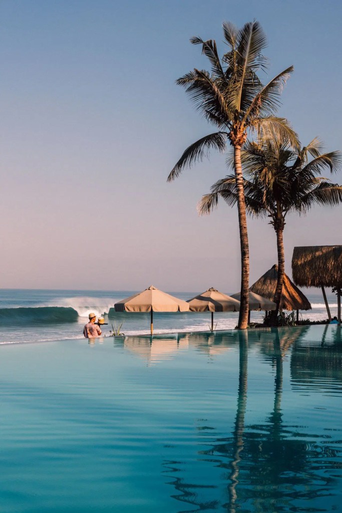 Infinity pool and ocean view at a beach club in Seminyak, Bali