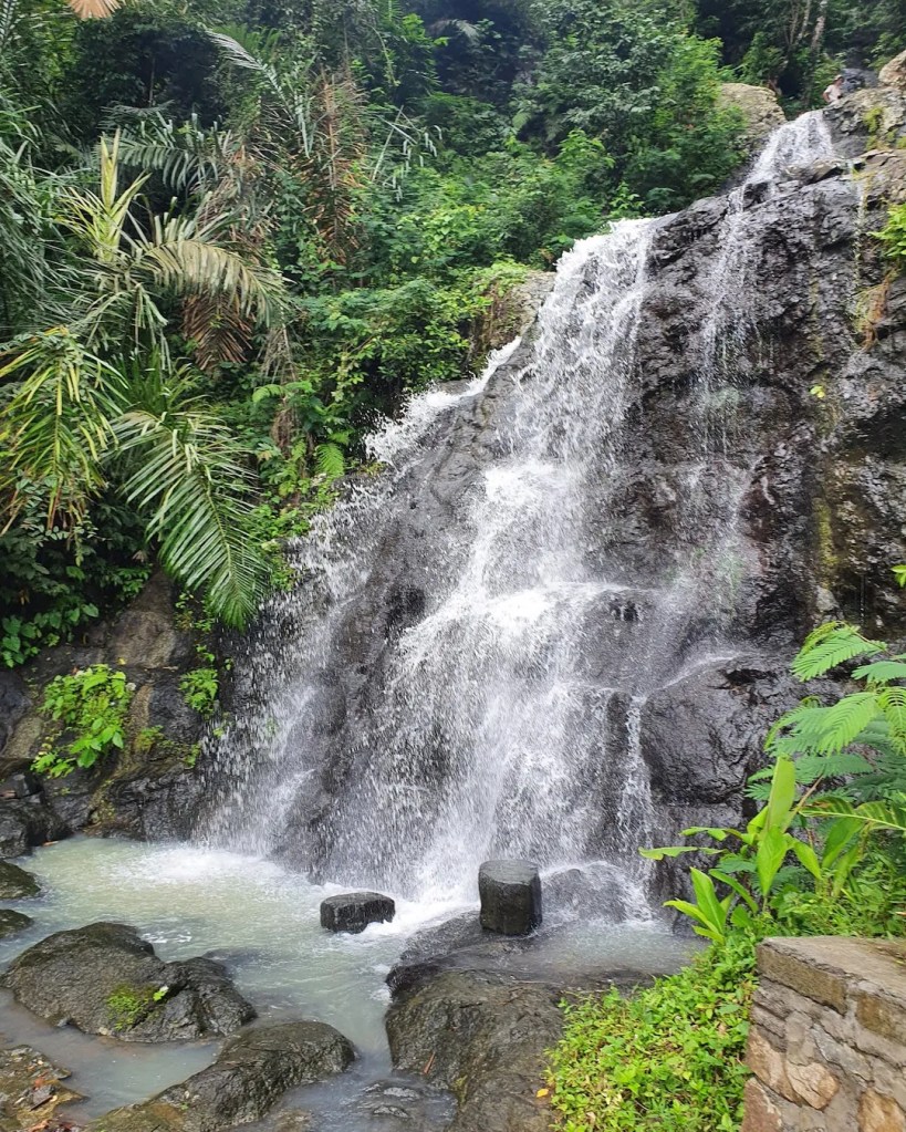 Gembleng Waterfall flowing through jungle rocks in Sidemen, Bali