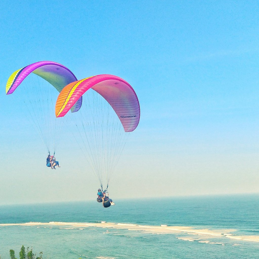 Paragliders flying over the southern cliffs of Uluwatu, Bali