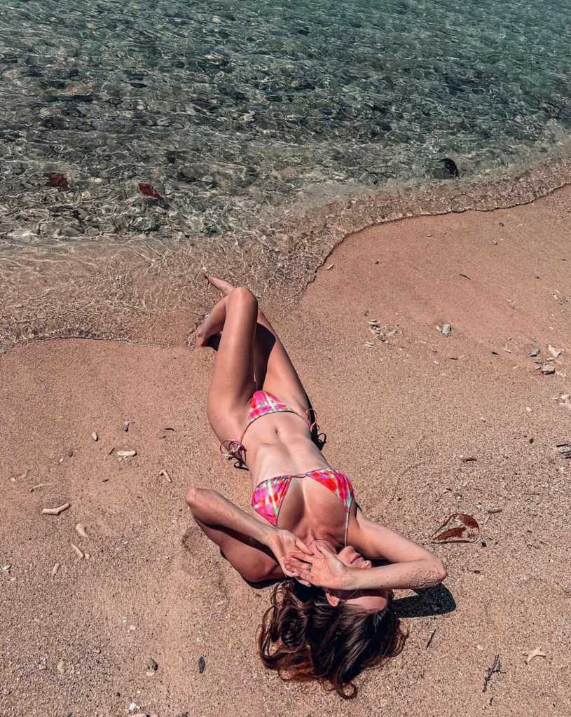 Girl lying down on the beach in her bikini with clear water in Gili Air Indonesia