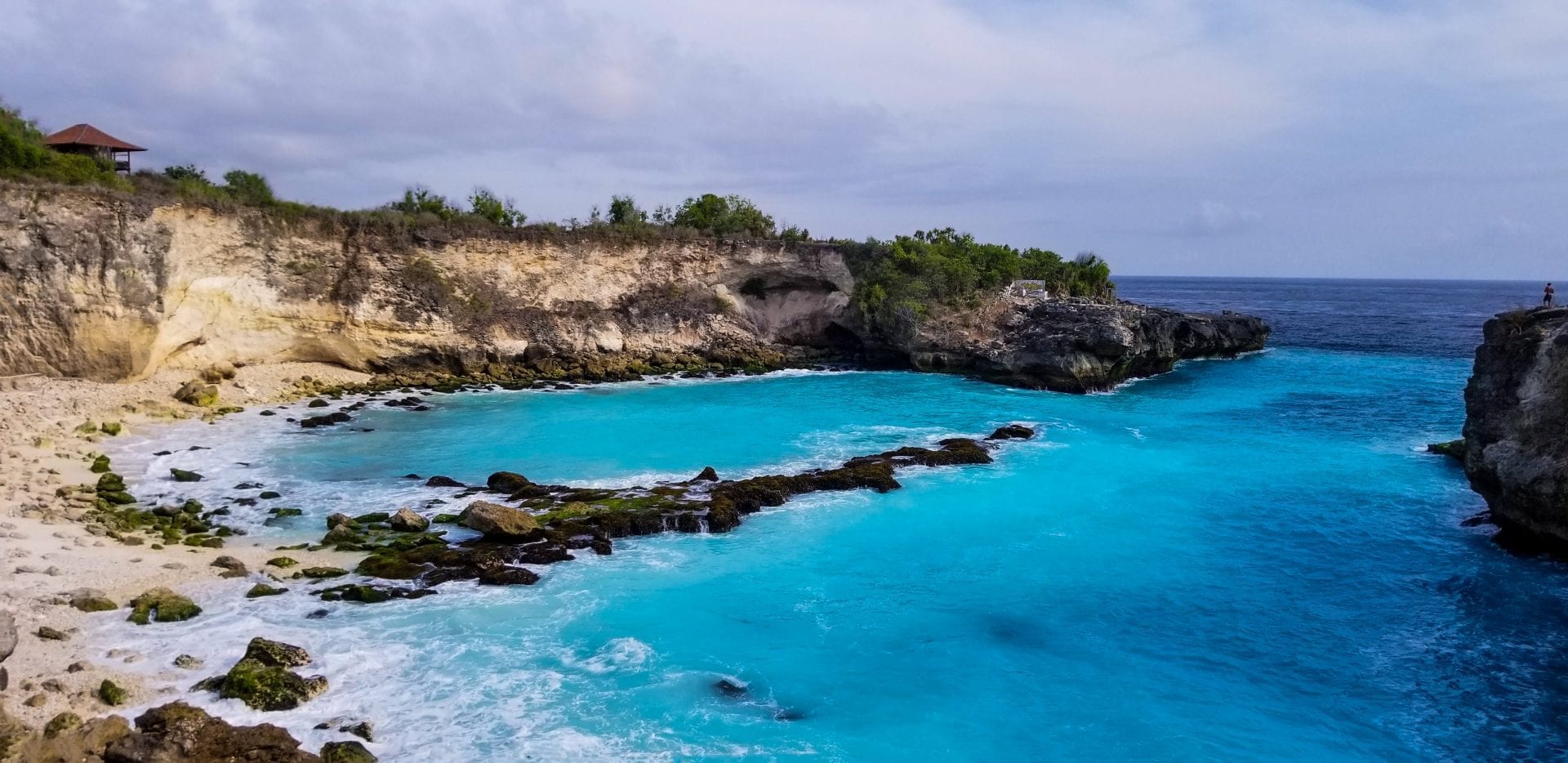 Bright blue ocean and rocky cliffs at Blue Lagoon on Nusa Ceningan