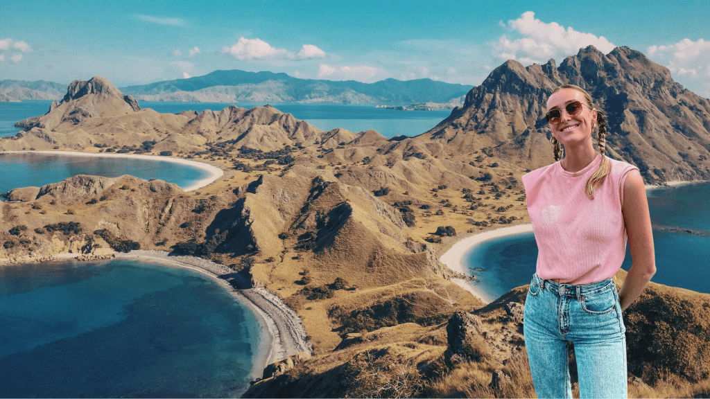 Travel creator standing in front of Komodo National Park hills, Padar island viewpoint and turquoise bays in Indonesia