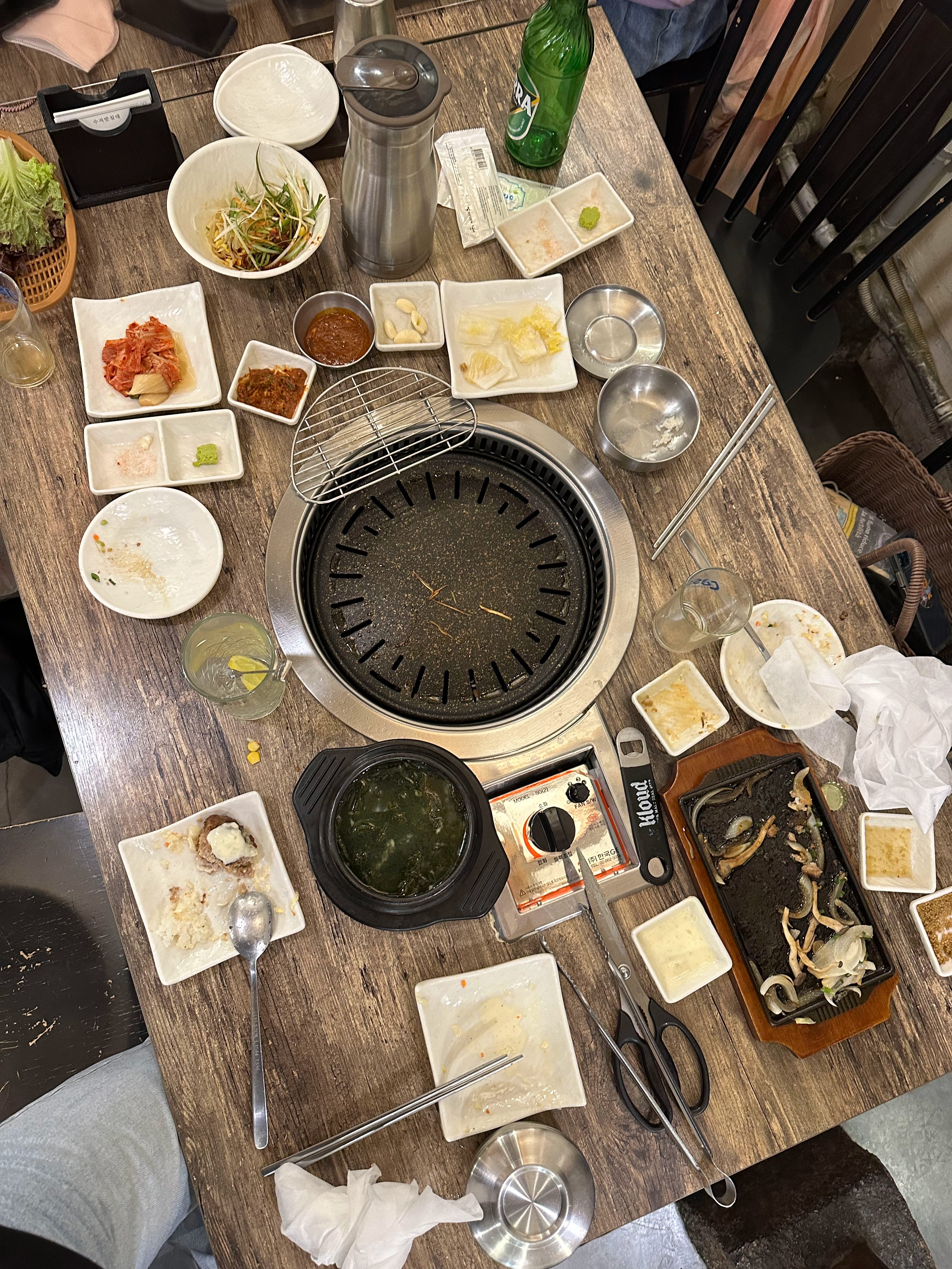 Korean barbecue table with side dishes, grill, and local food