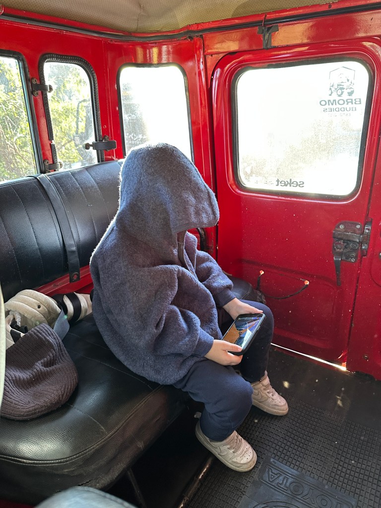 Traveler inside a red jeep during a Mount Bromo sunrise tour
