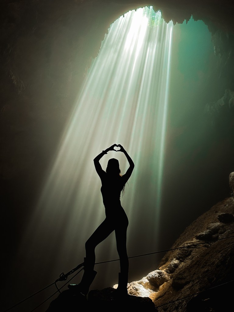 Jomblang Cave in Java with sunlight beams shining into the underground cave