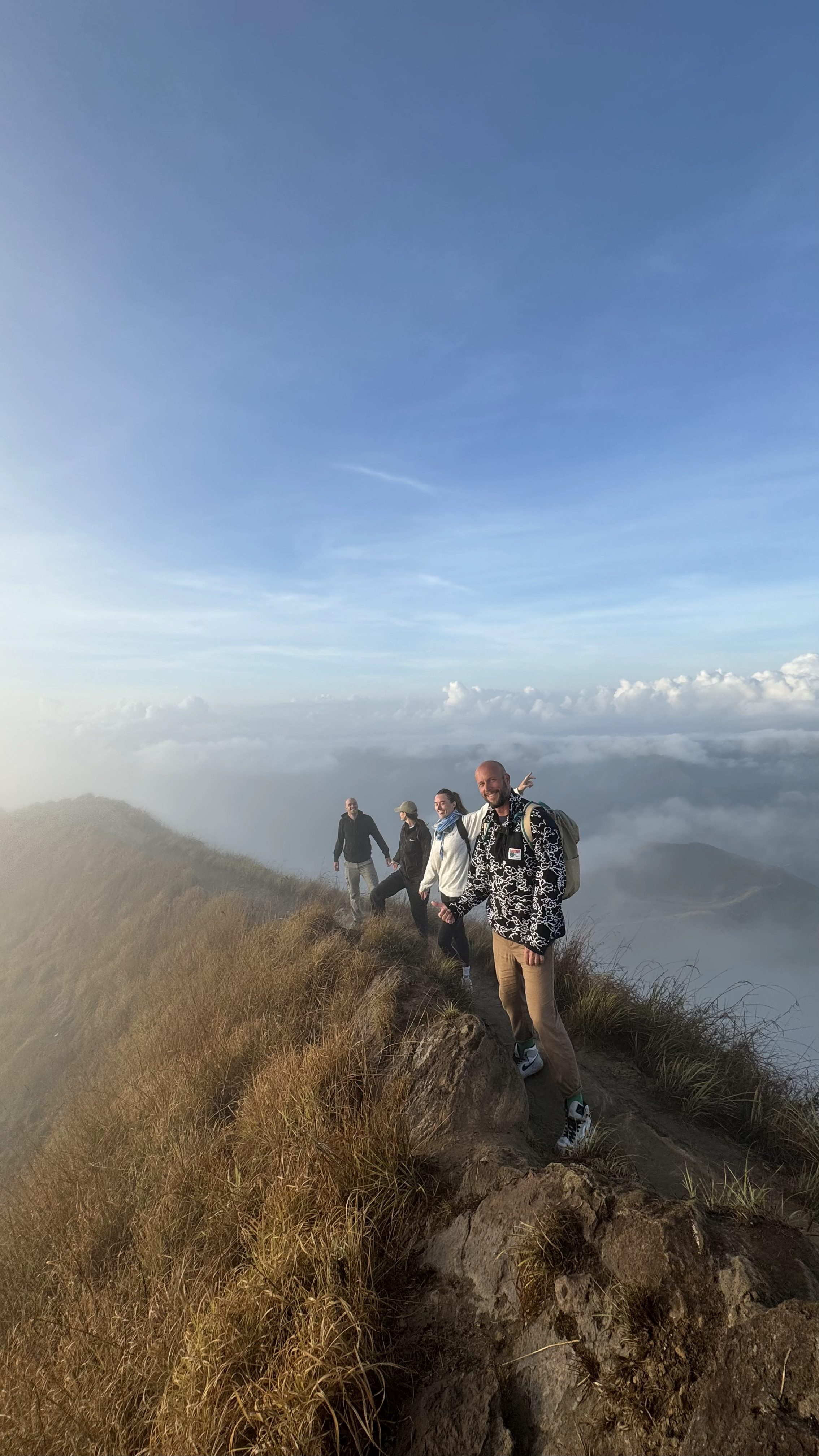 Hikers walking along the Mount Batur crater ridge at sunrise