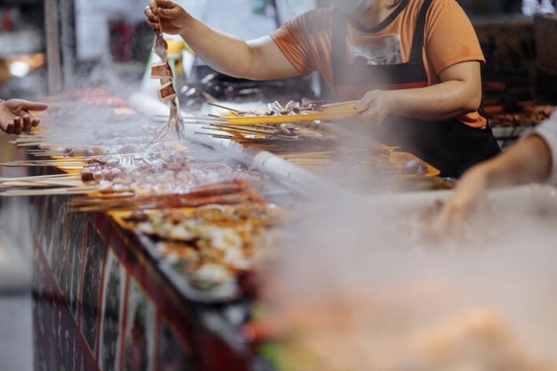 Street food vendor grilling local snacks in Malang, East Java