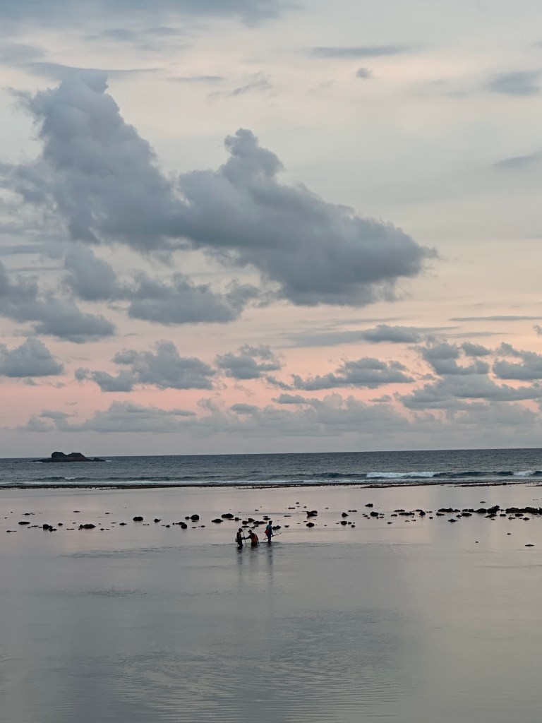 Lombok beach sunset with tide pools and dramatic cloudy sky