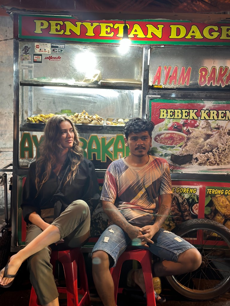 Carlijn sitting at a local street food stall in Java, Indonesia, during a night food stop.
