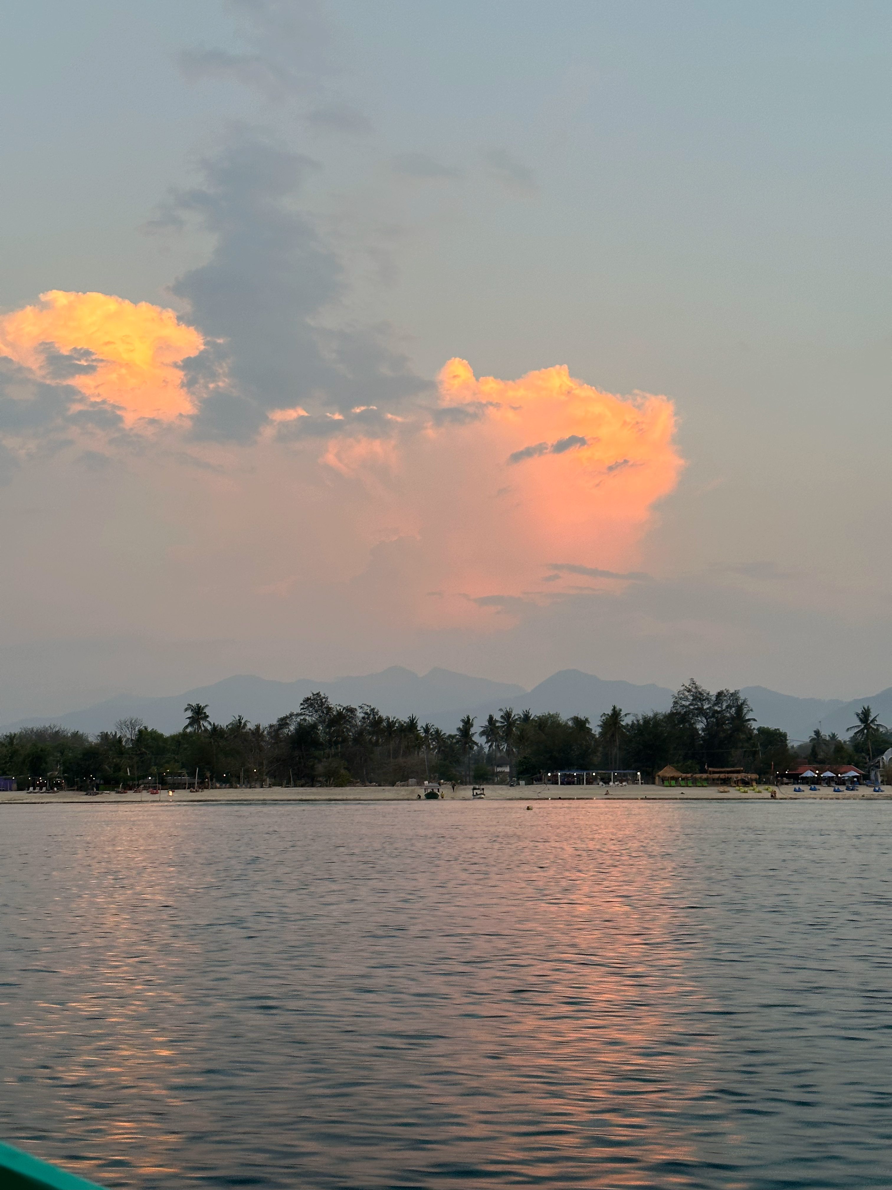 Sunset clouds over the west coast of Gili Air with views toward Bali and Mount Agung