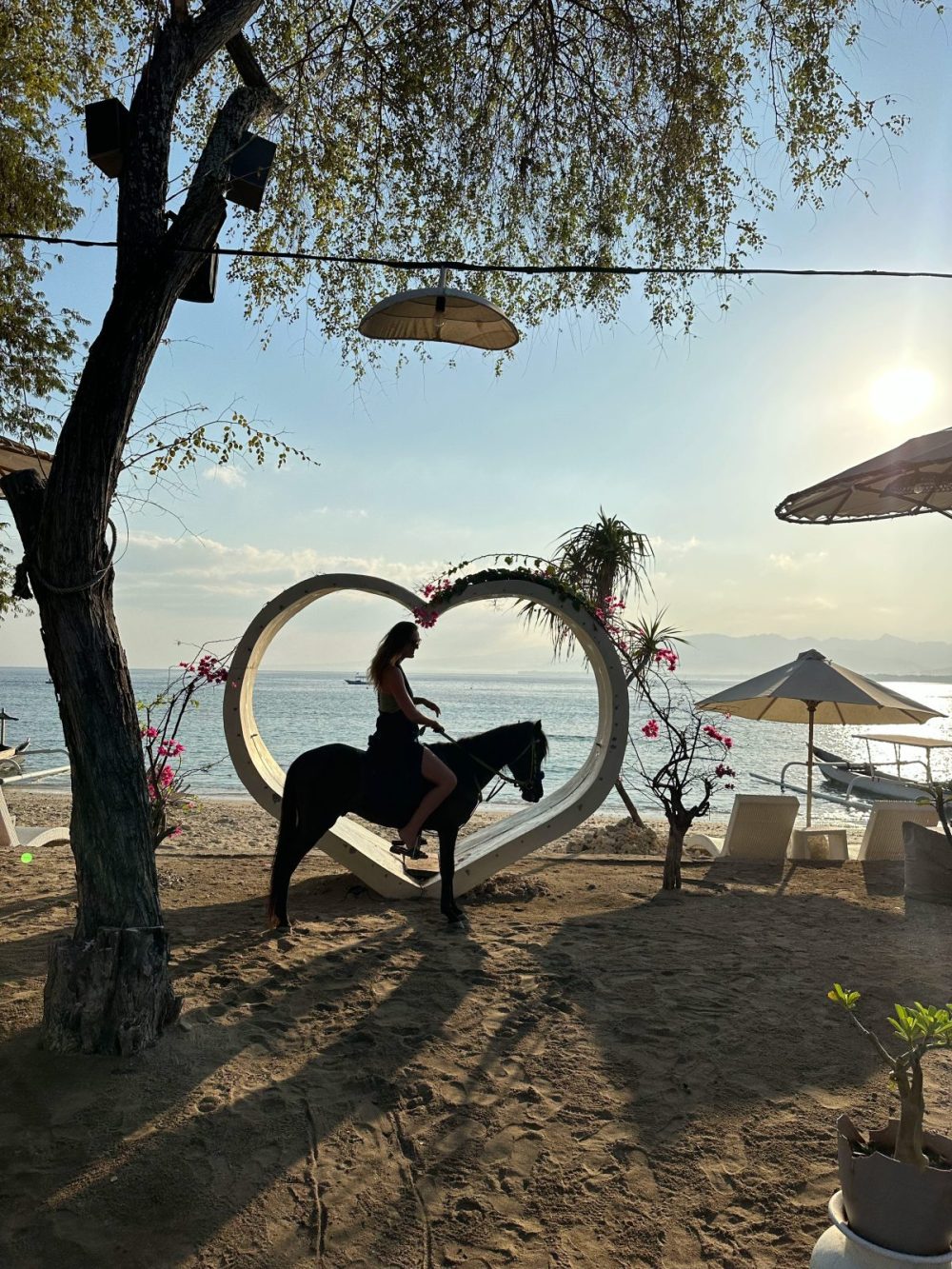 Traveler sitting on a horse at sunrise on Gili Air, Indonesia
