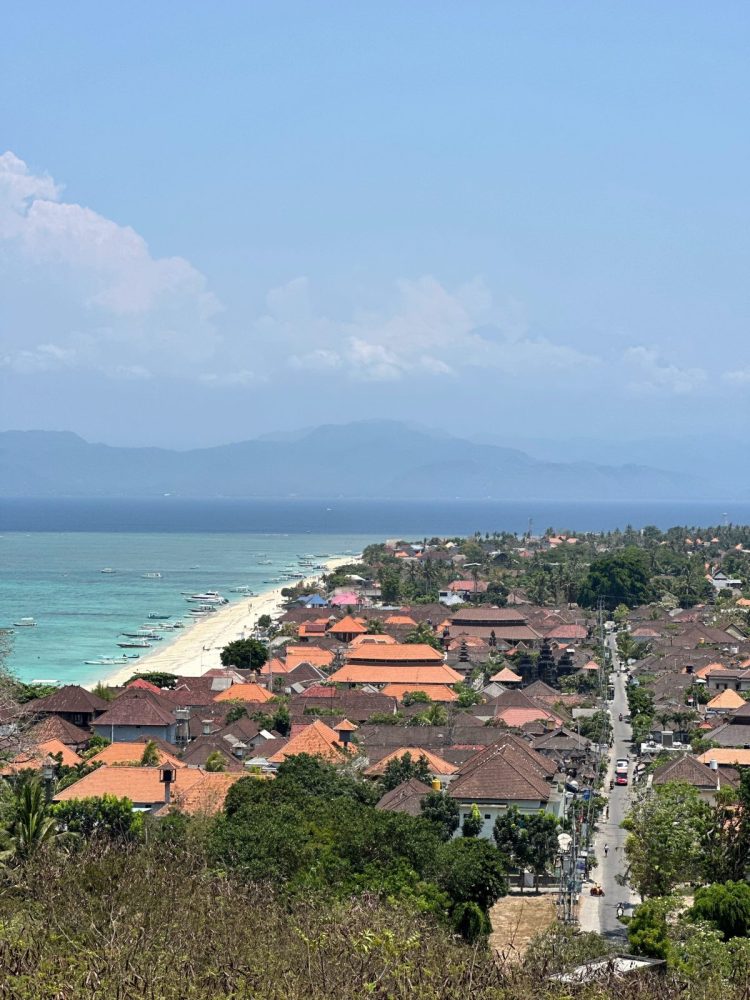 View over Nusa Lembongan coastline with turquoise water and village rooftops in Bali