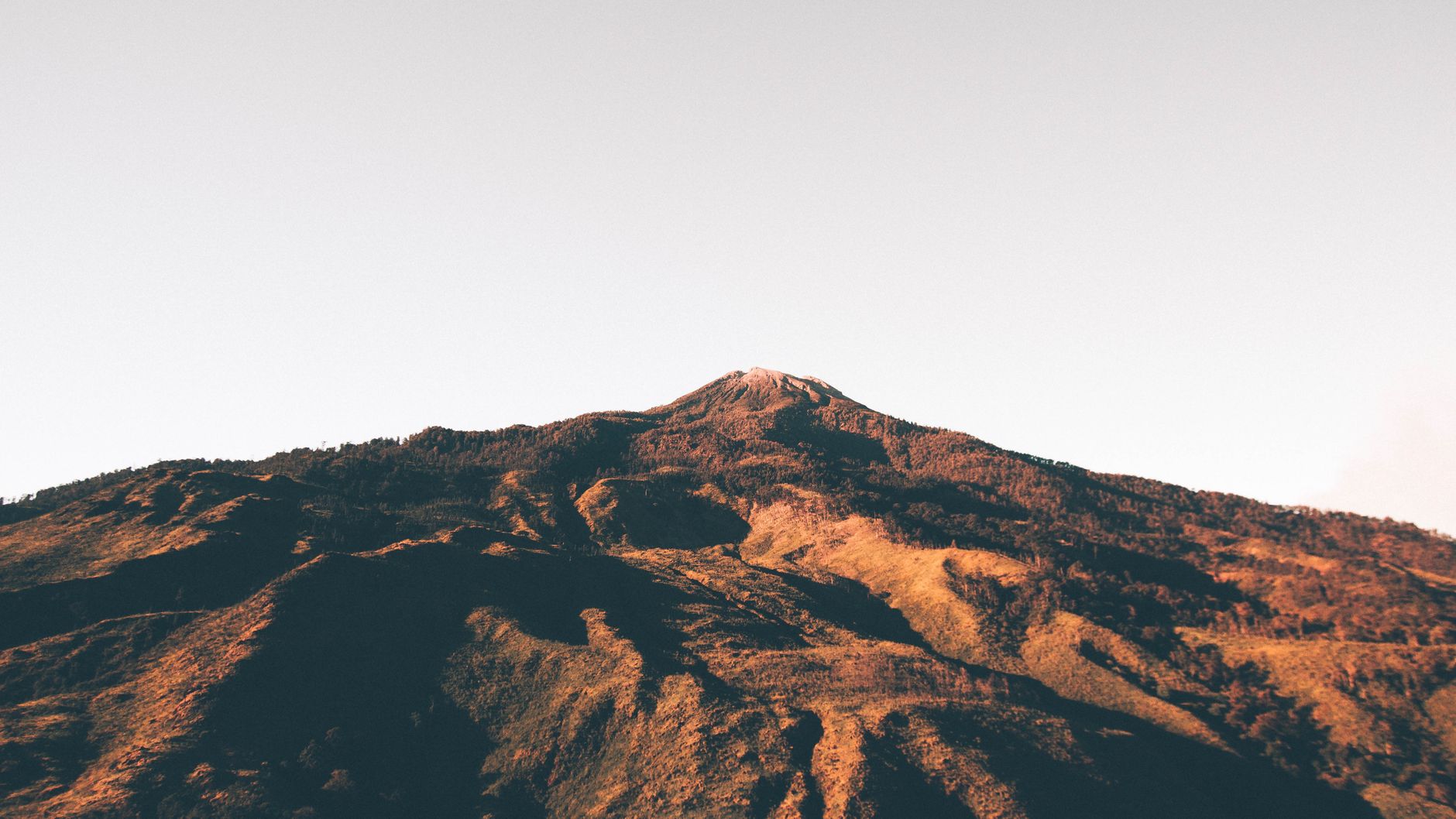 Orange sunrise light over the volcanic slopes of Mount Rinjani in Lombok