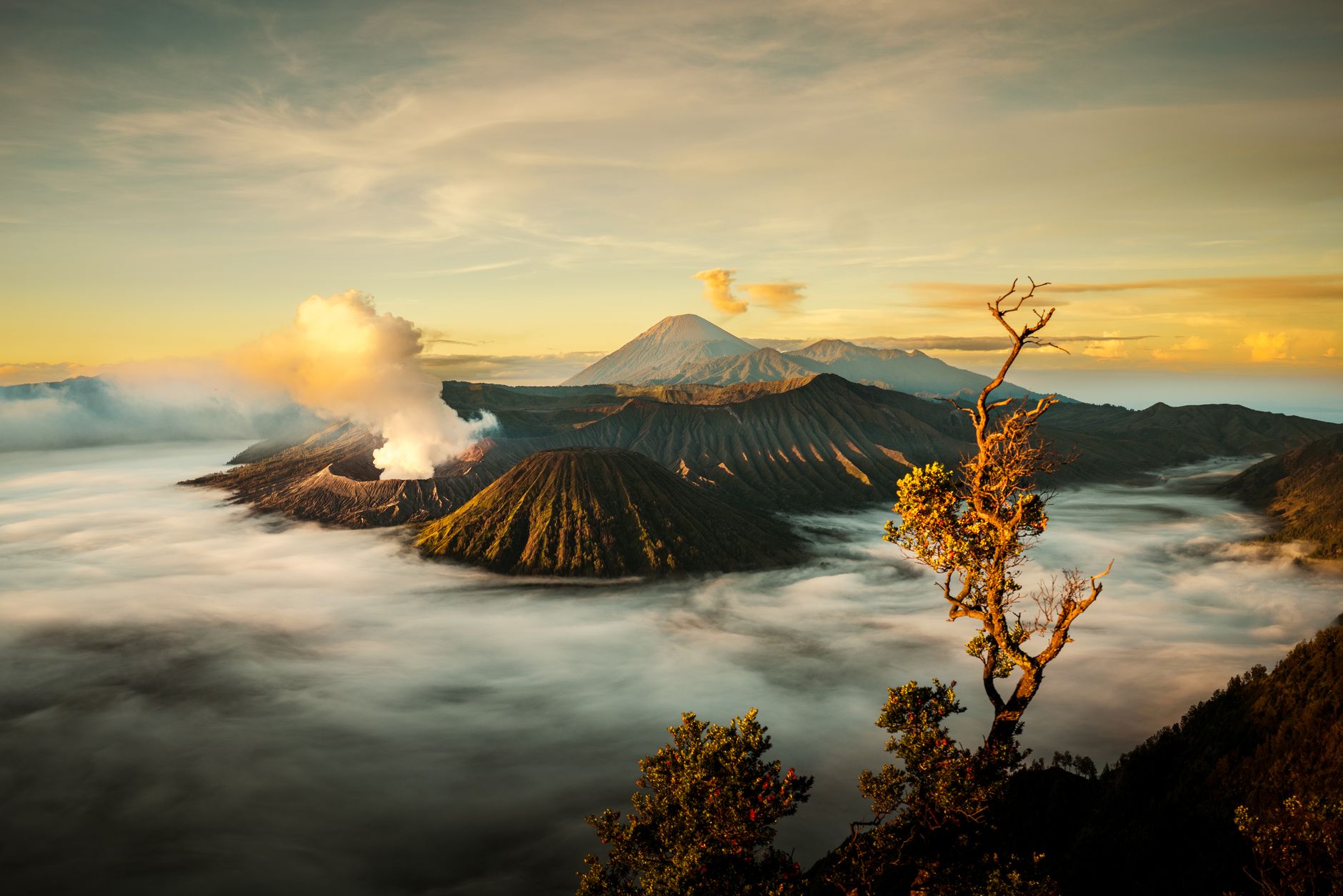 Mount Bromo sunrise view in Java with smoking volcano crater and mountain landscape