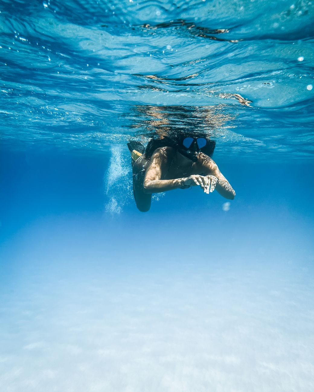 Snorkeler swimming in clear blue water at Blue Lagoon Bali