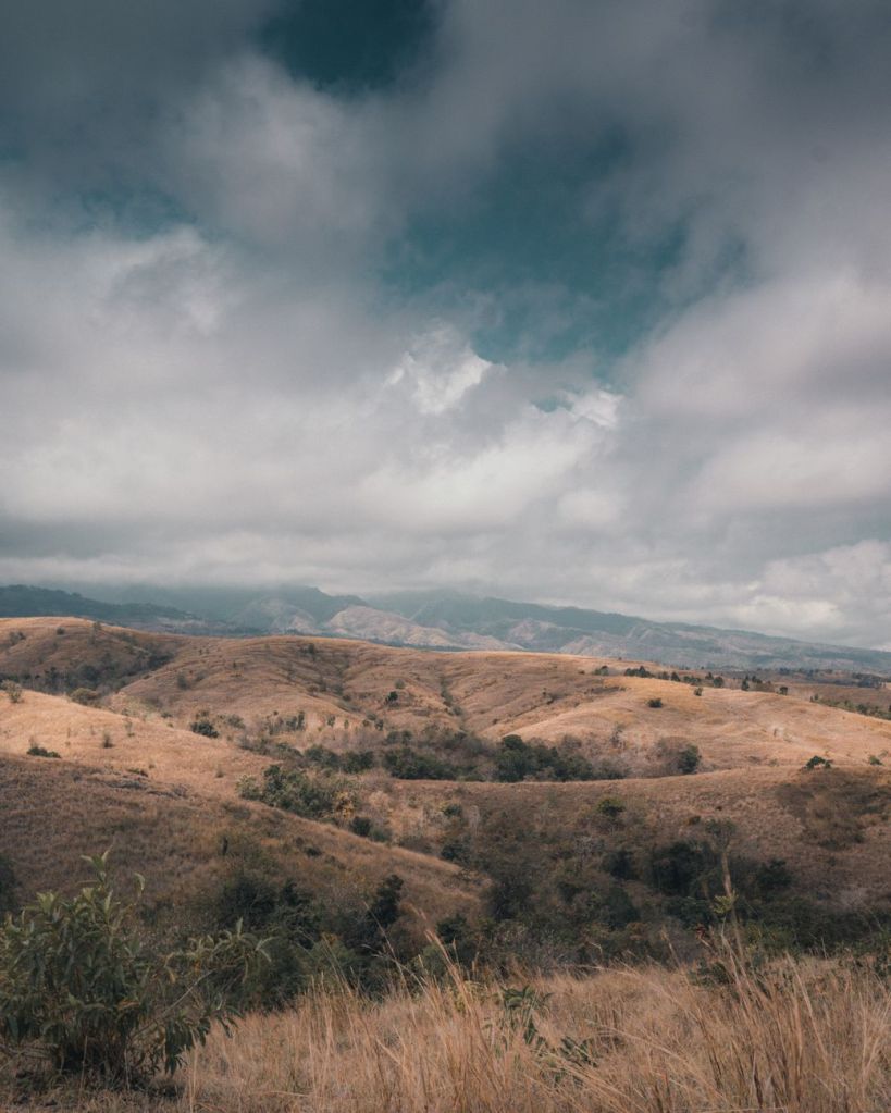 Rolling hills and dramatic cloudy sky in Sumba Indonesia