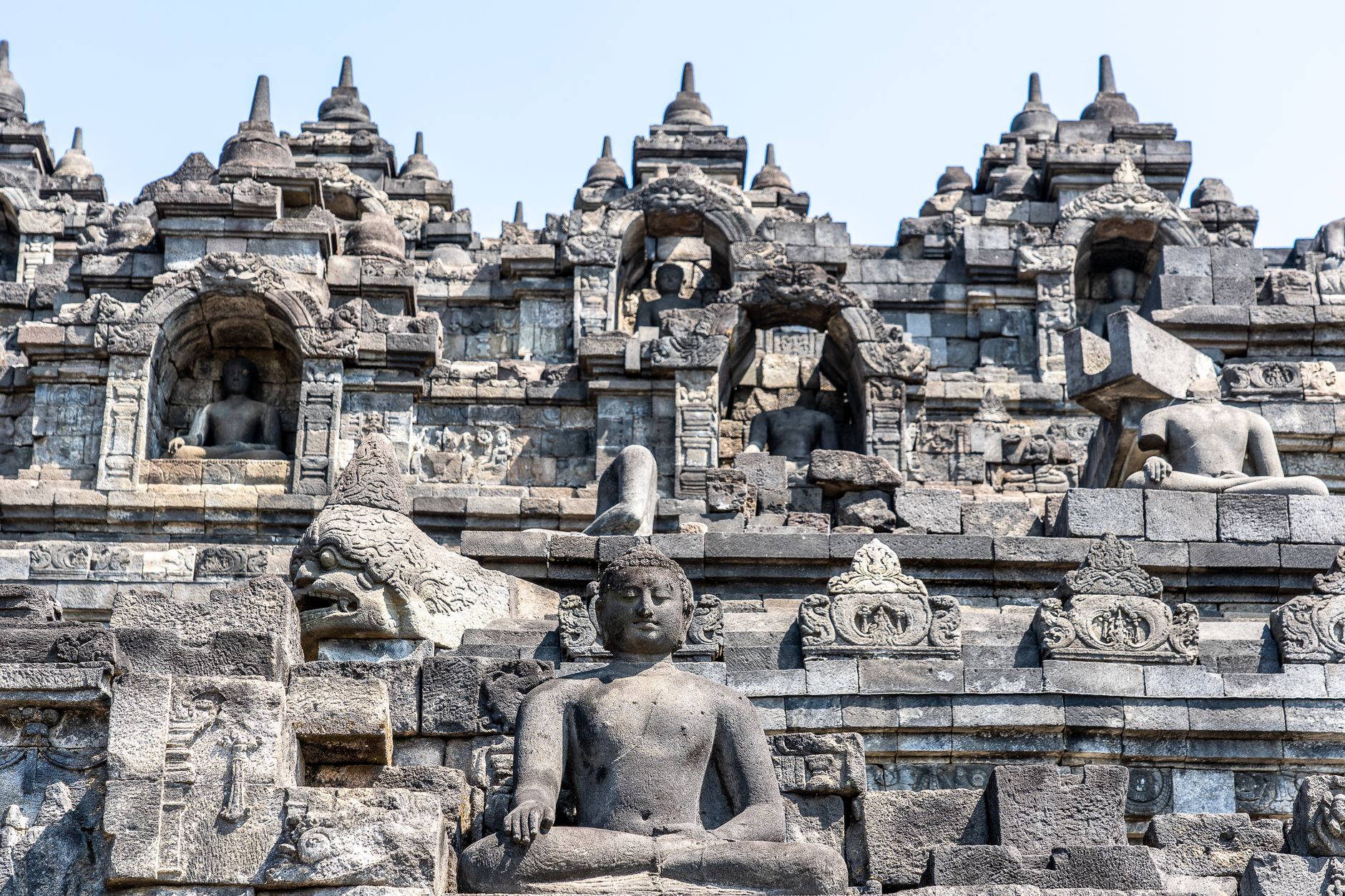 Stone entrance and Buddha statue details at Borobudur Temple in Central Java