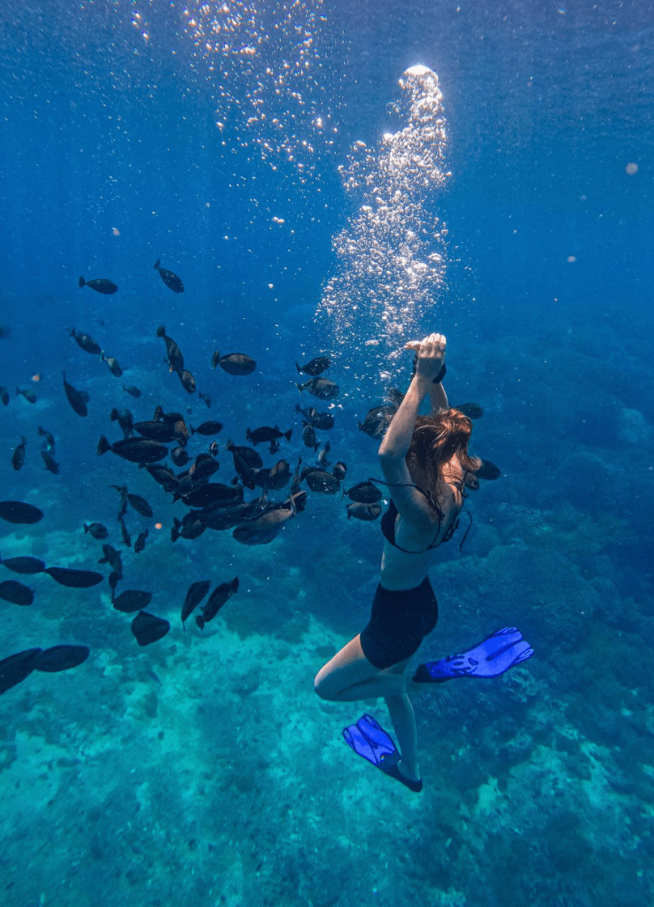 Snorkeler swimming with tropical fish near Nusa Lembongan