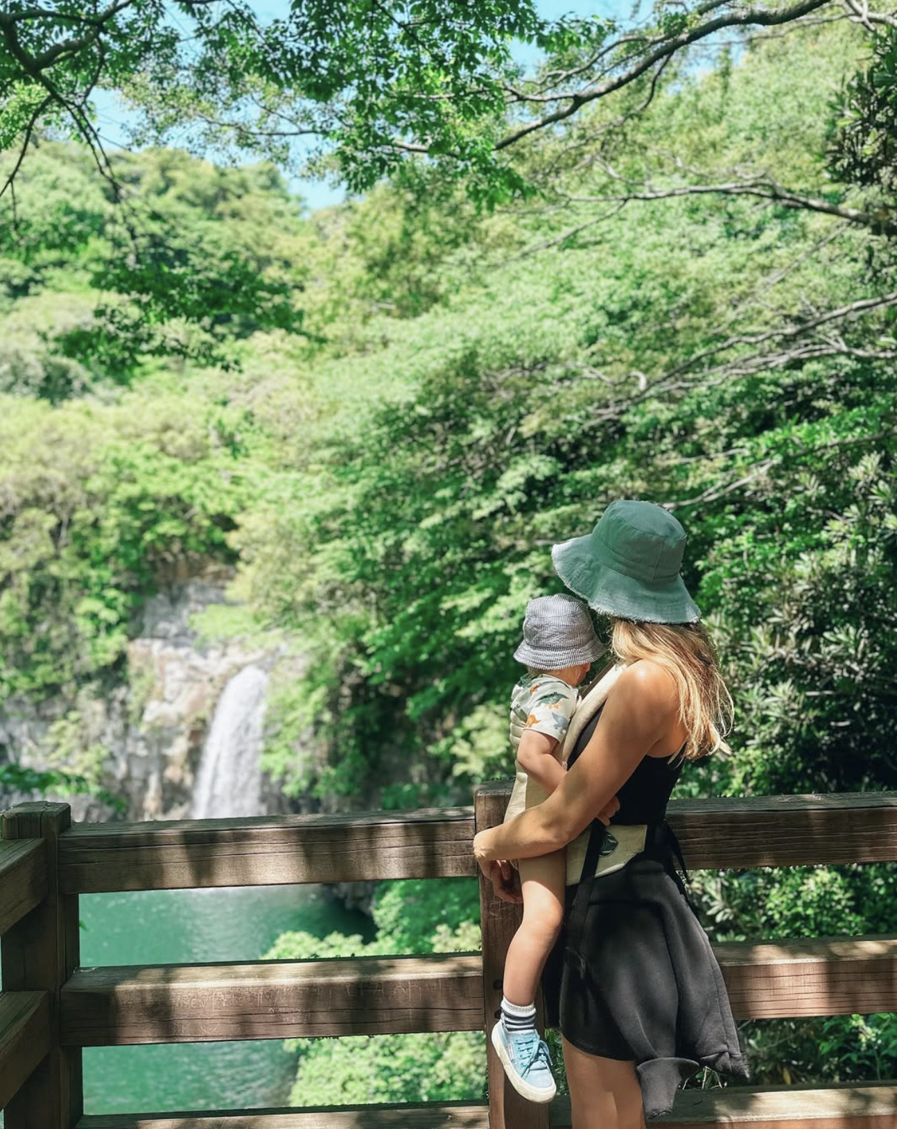 Carlijn holding a child near a waterfall on Jeju Island, South Korea