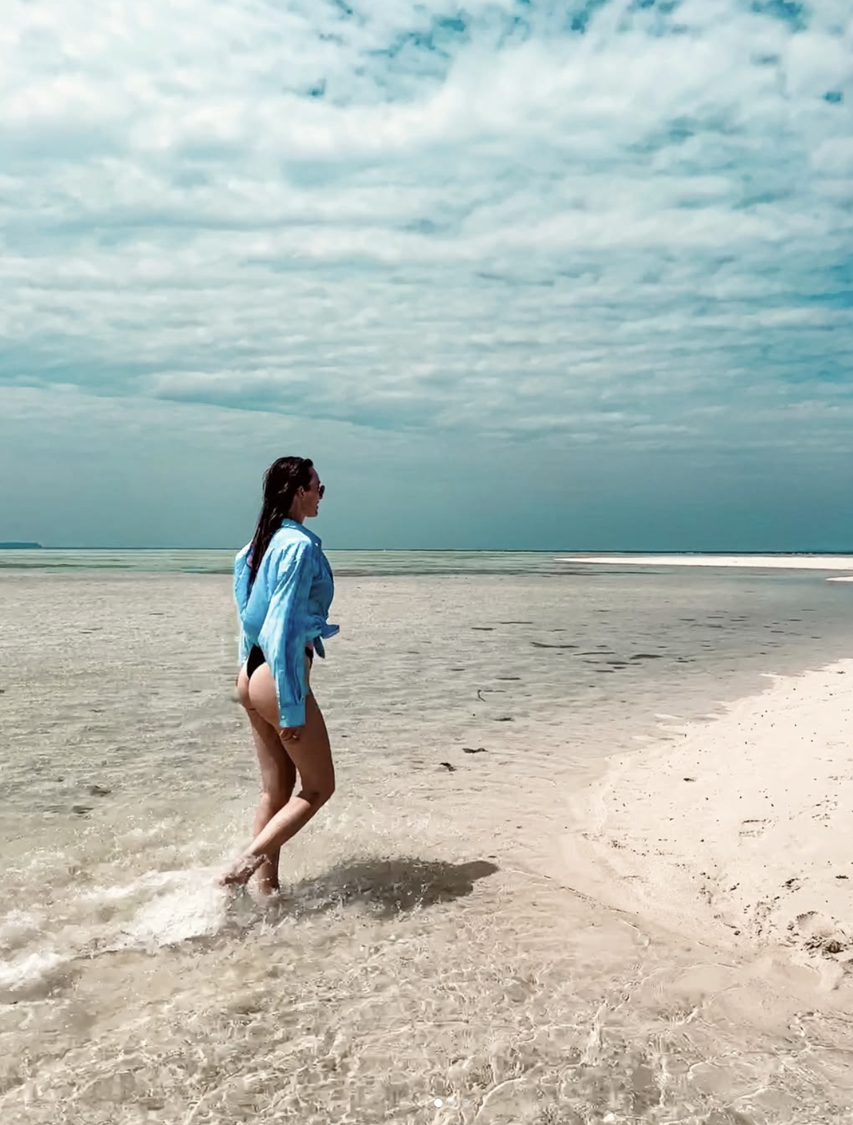 Woman walking through shallow water on a quiet Karimunjawa island during a private boat tour