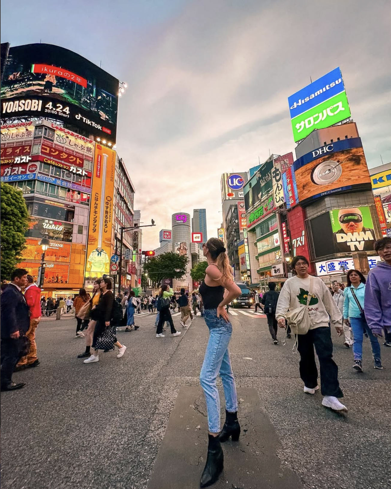 Carlijn standing at Shibuya Crossing in Tokyo with bright city lights