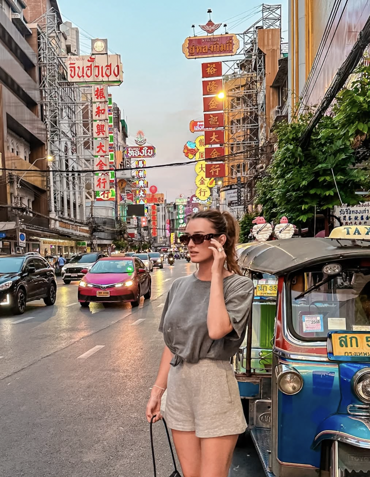 Busy Bangkok Chinatown street with tuk-tuks, signs, and traffic