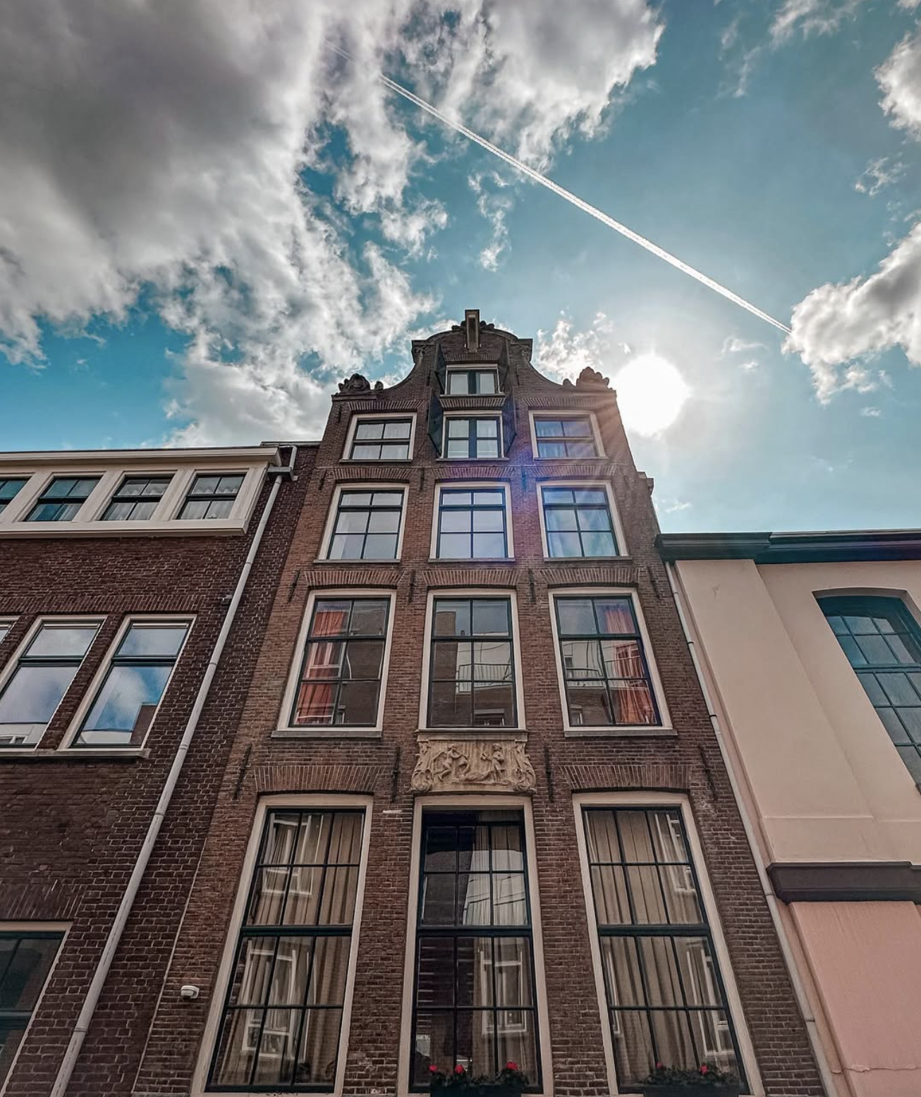 Historic canal house in Amsterdam with blue sky above