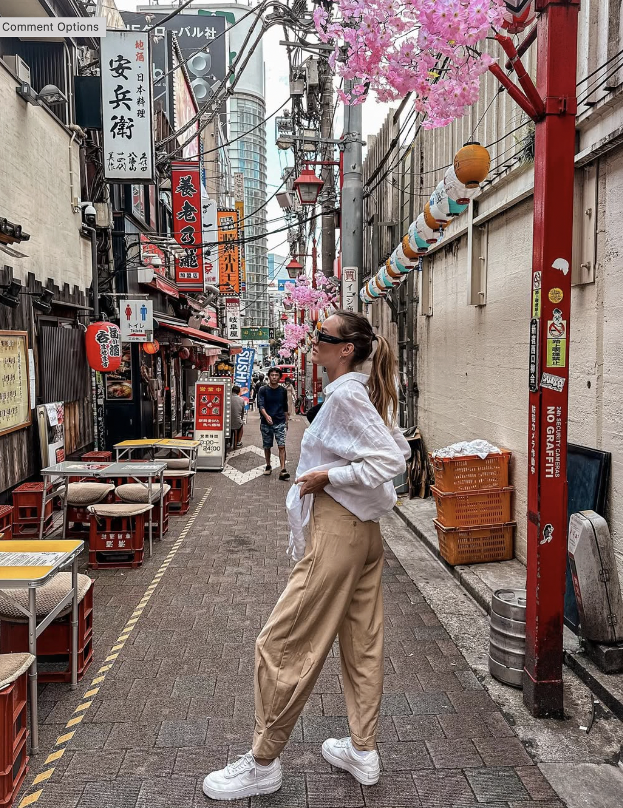 Carlijn walking through a narrow Tokyo street with Japanese signs and lanterns