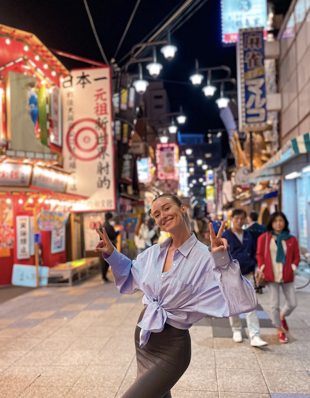 Carlijn smiling in a lively Japanese city street at night