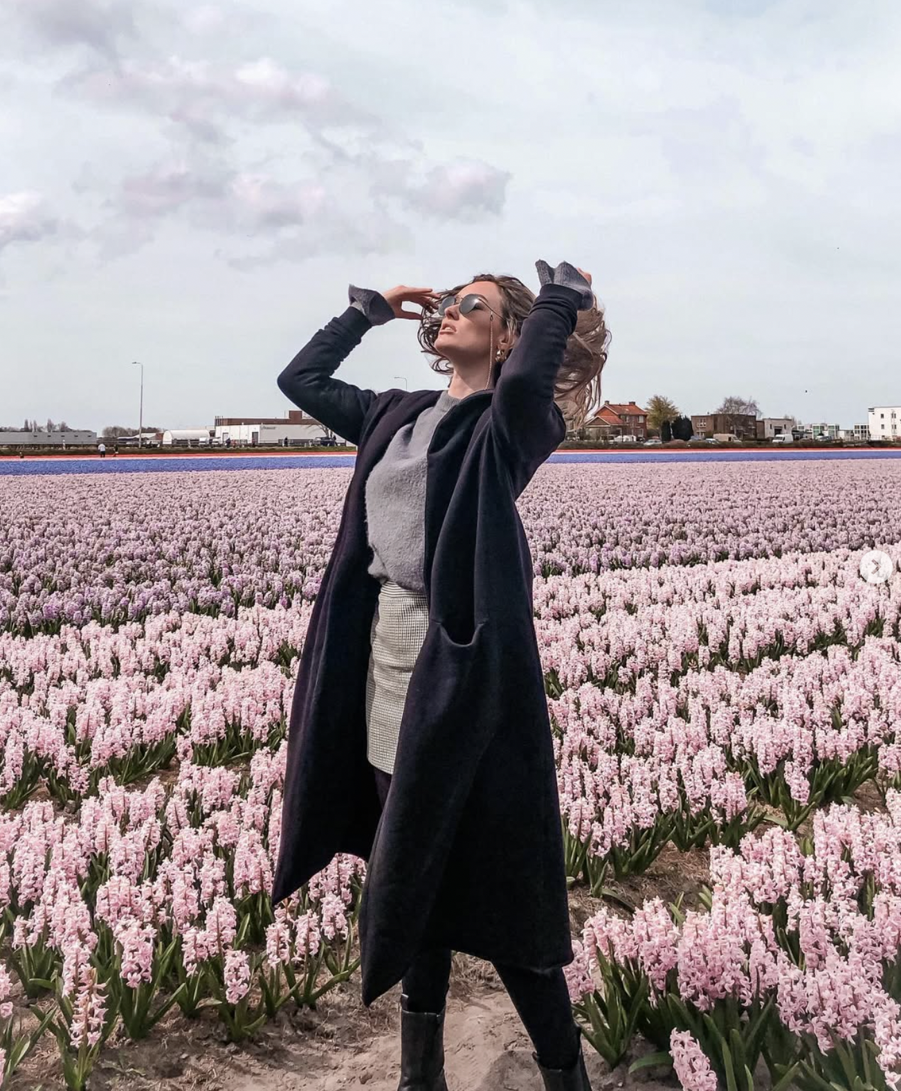 Carlijn standing in a pink tulip flower field in the North of Netherlands