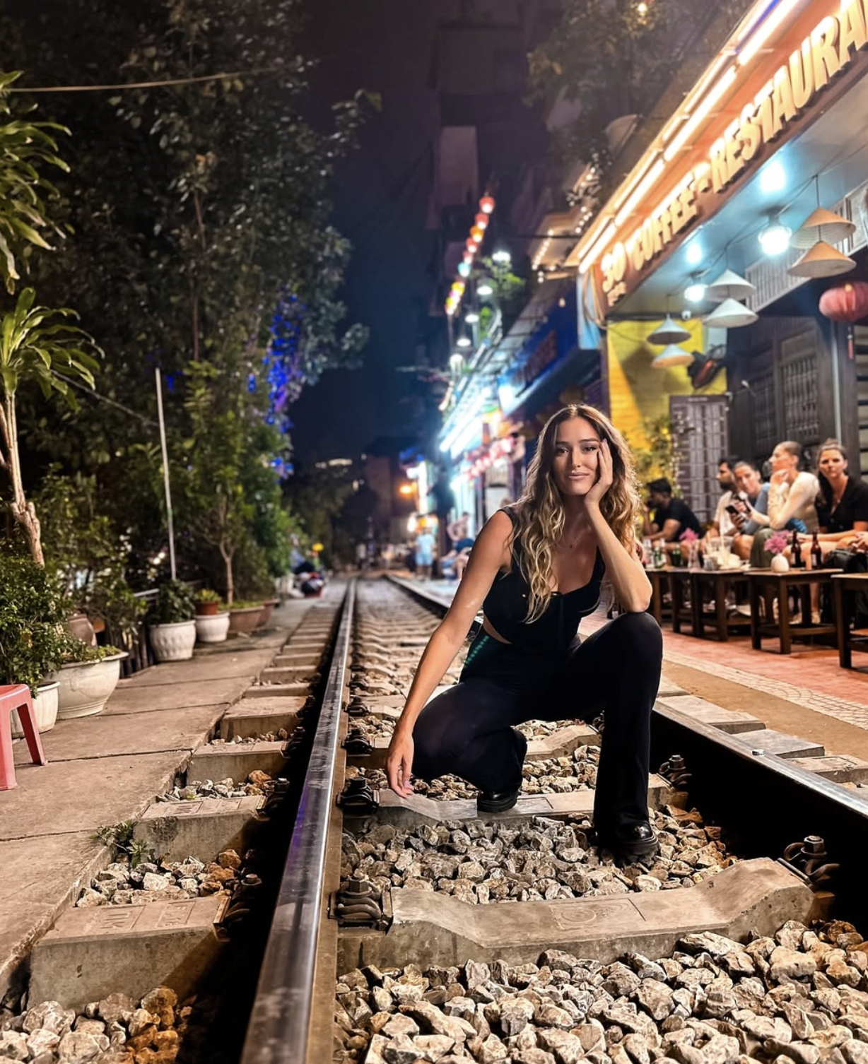 Carlijn sitting on Hanoi Train Street at night in Vietnam