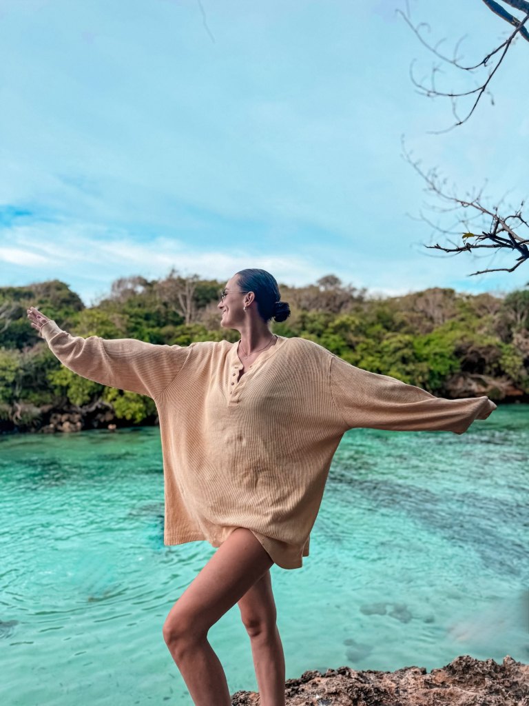 Carlijn standing by turquoise water in Sumba for her Sumba travel guide