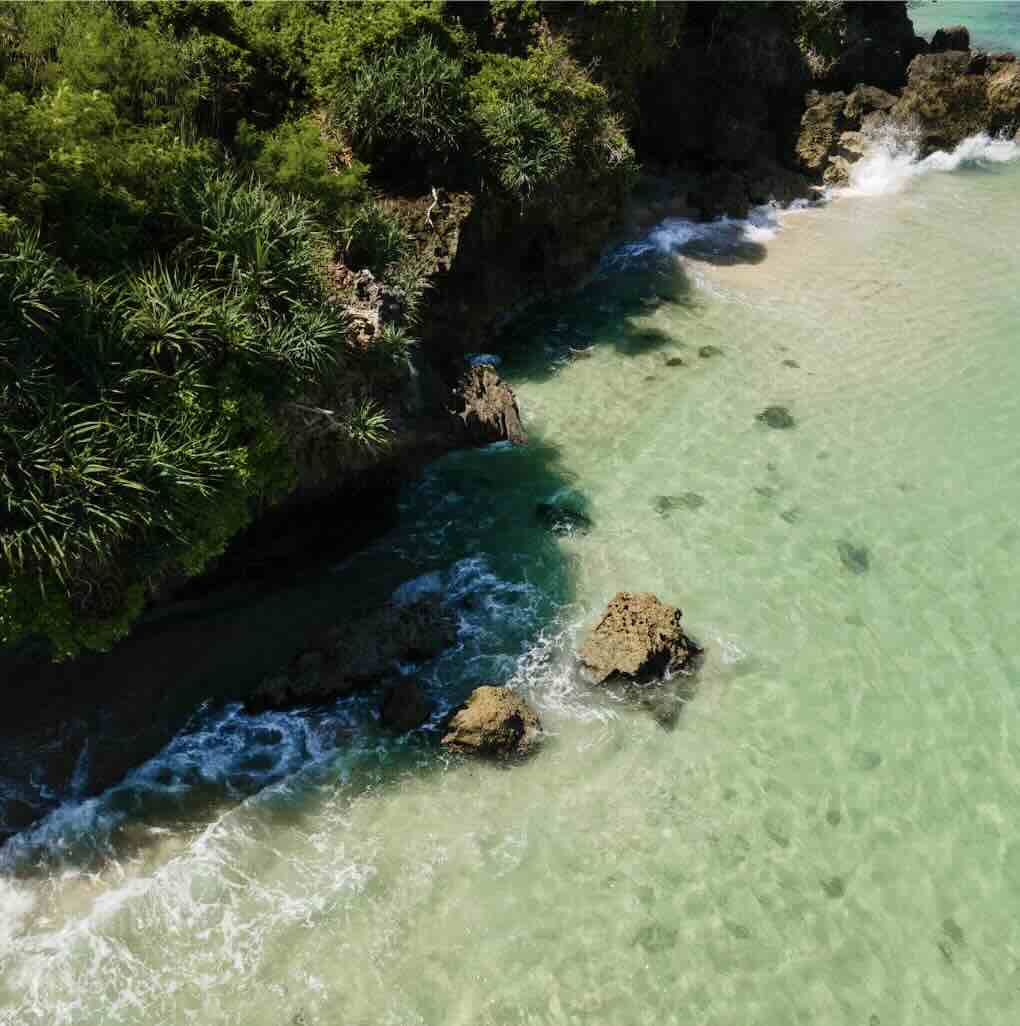 Clear turquoise water and rocky cliffs at a beach in Uluwatu, Bali