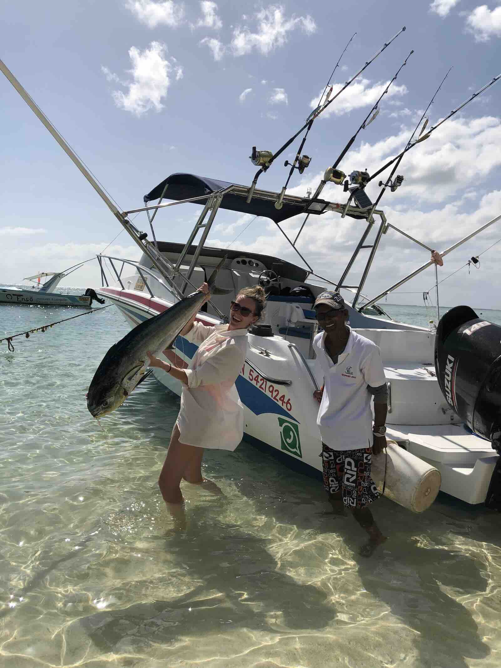 Freshly caught game fish beside a fishing boat during a deep sea fishing trip in Mauritius.