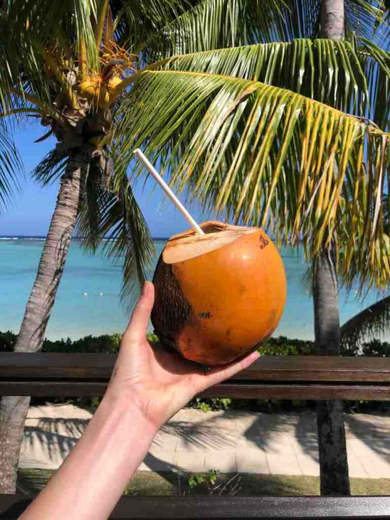 A hand holding a coconut at the luxury resort Lux Grand Gaube in Mauritius