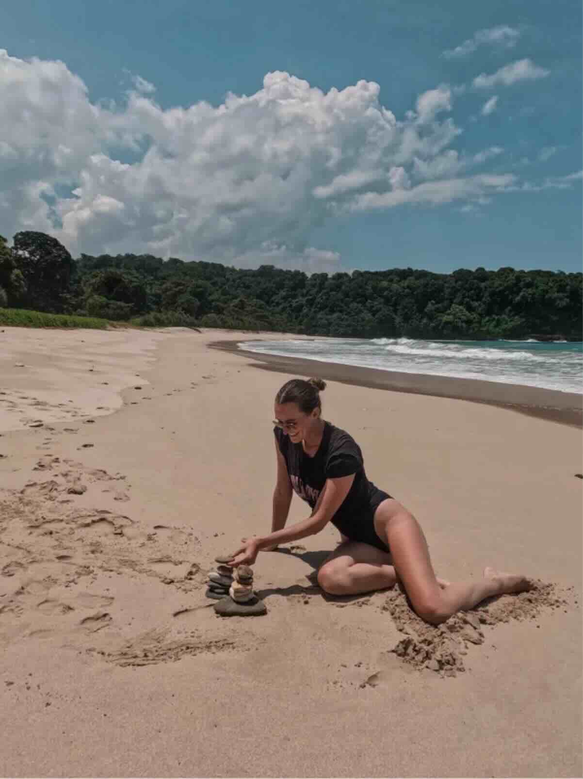 Traveler sitting on an empty sandy beach in Sumba, Indonesia