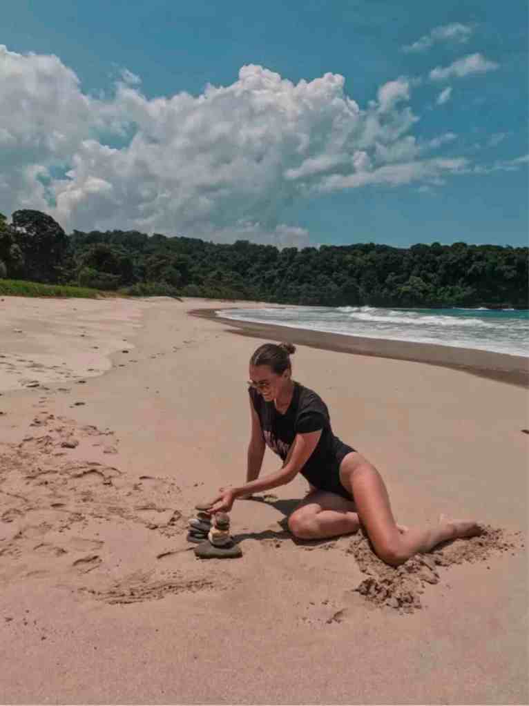 Traveler sitting on an empty sandy beach in Sumba, Indonesia