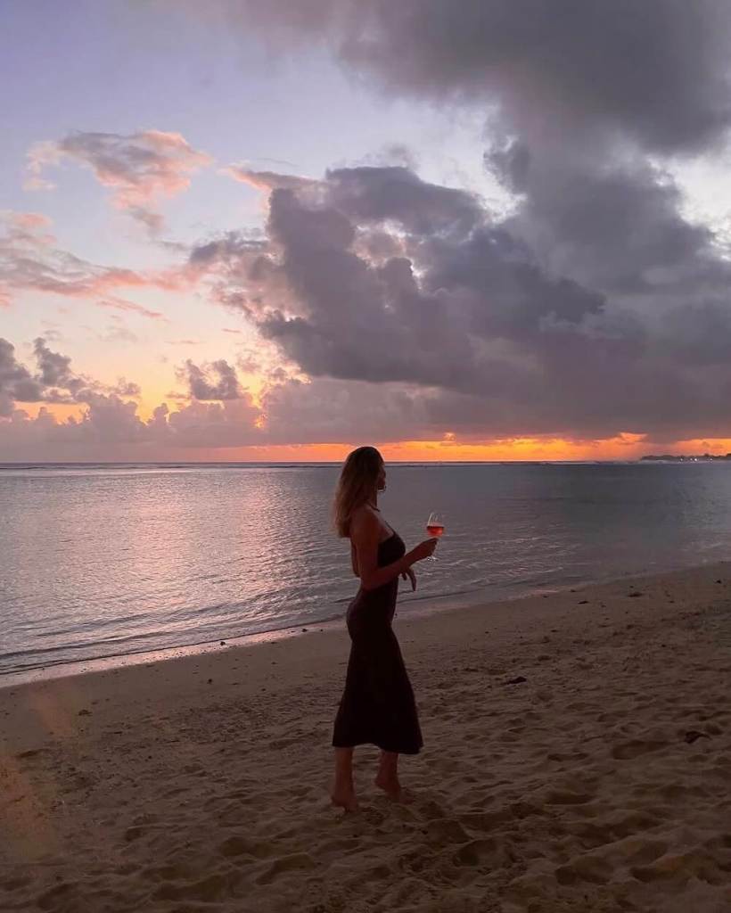 Woman in a beautiful dress enjoying sunset on a tropical beach in Mauritius.
