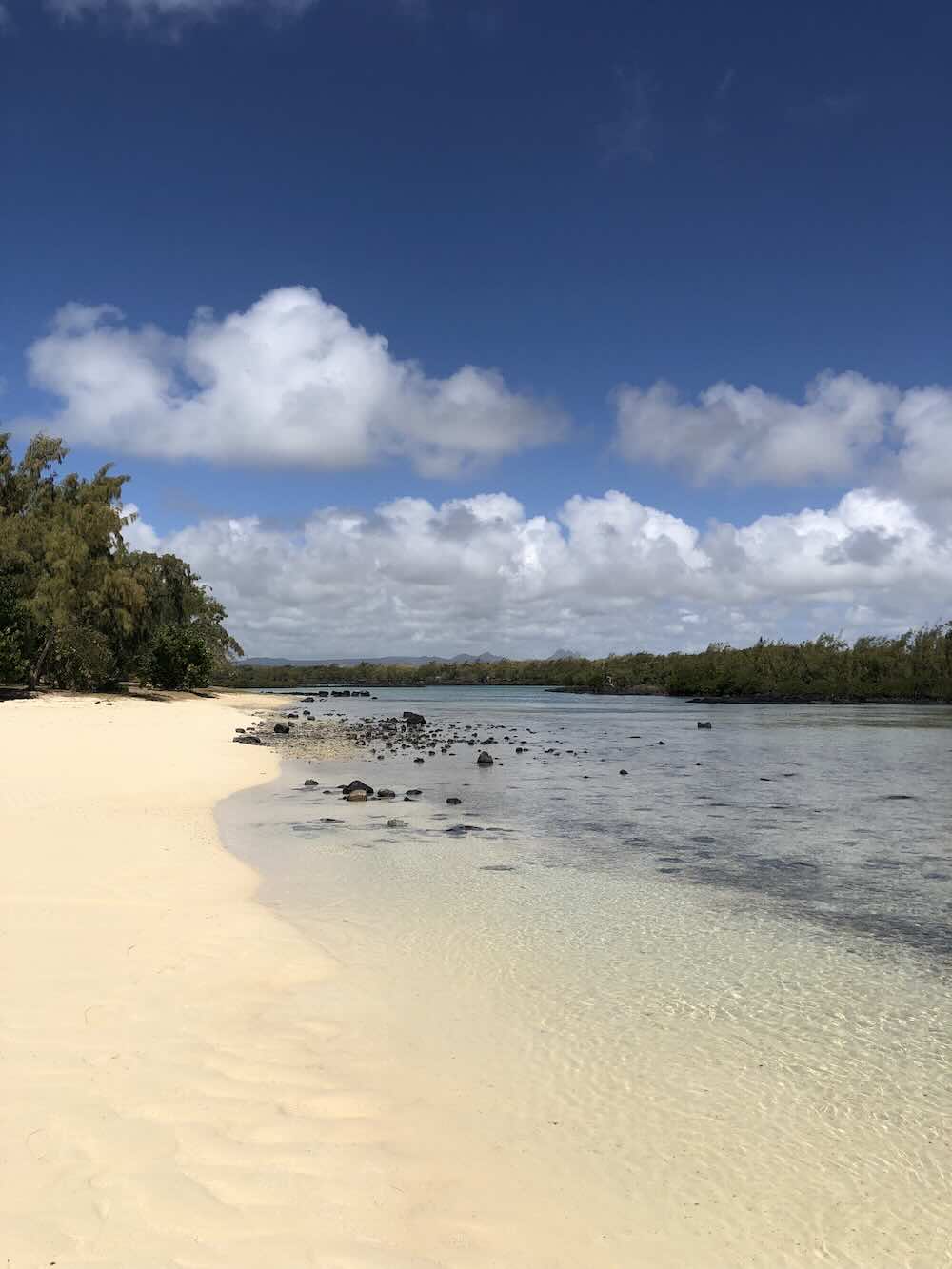 Quiet white sand beach with shallow turquoise water at Île aux Cerfs in Mauritius.