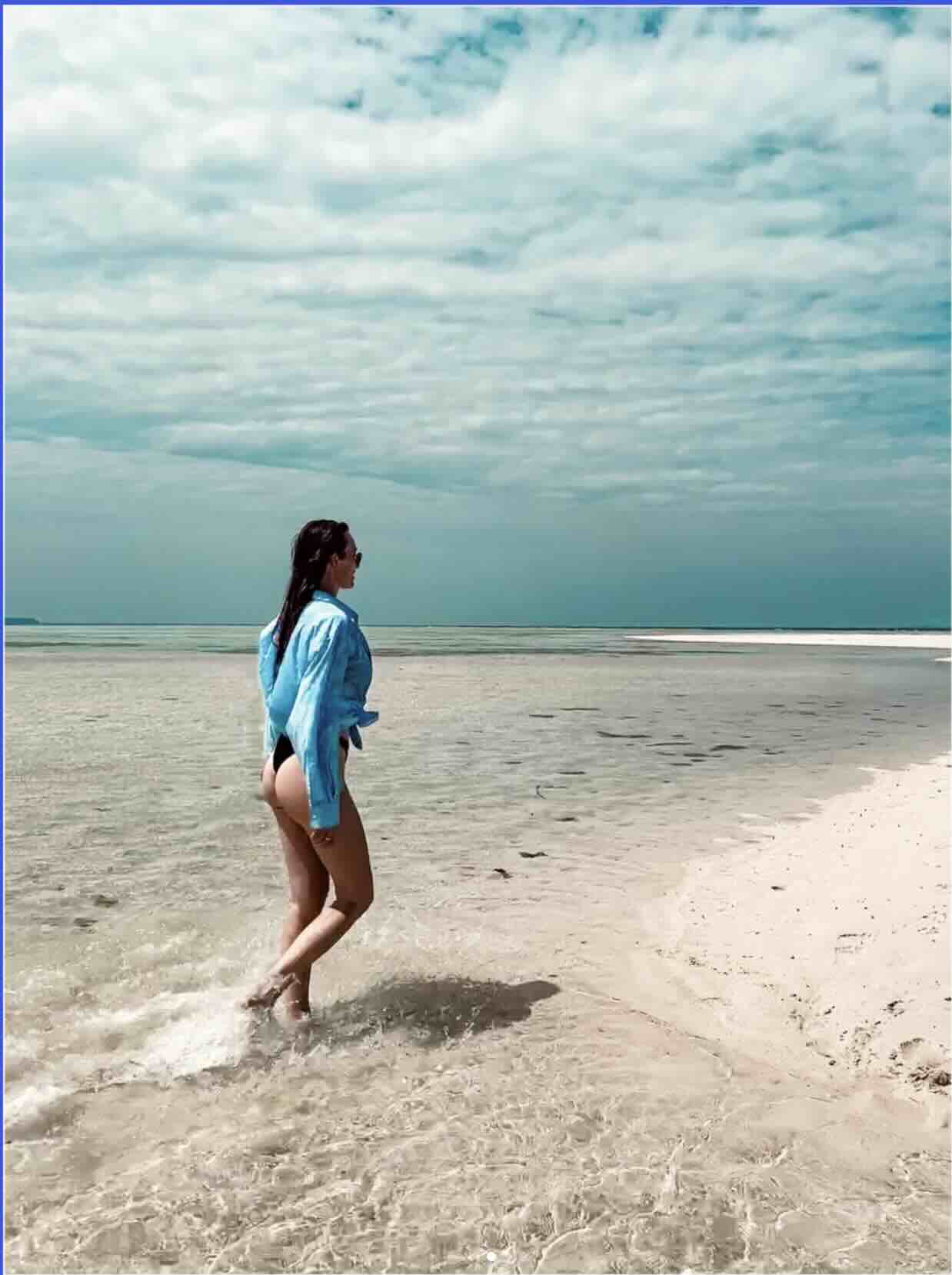 Traveler walking along a quiet white sand beach in Karimunjawa, Java
