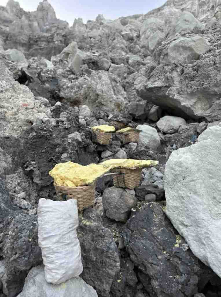 Sulfur baskets on the rocky trail inside Kawah Ijen crater in Java