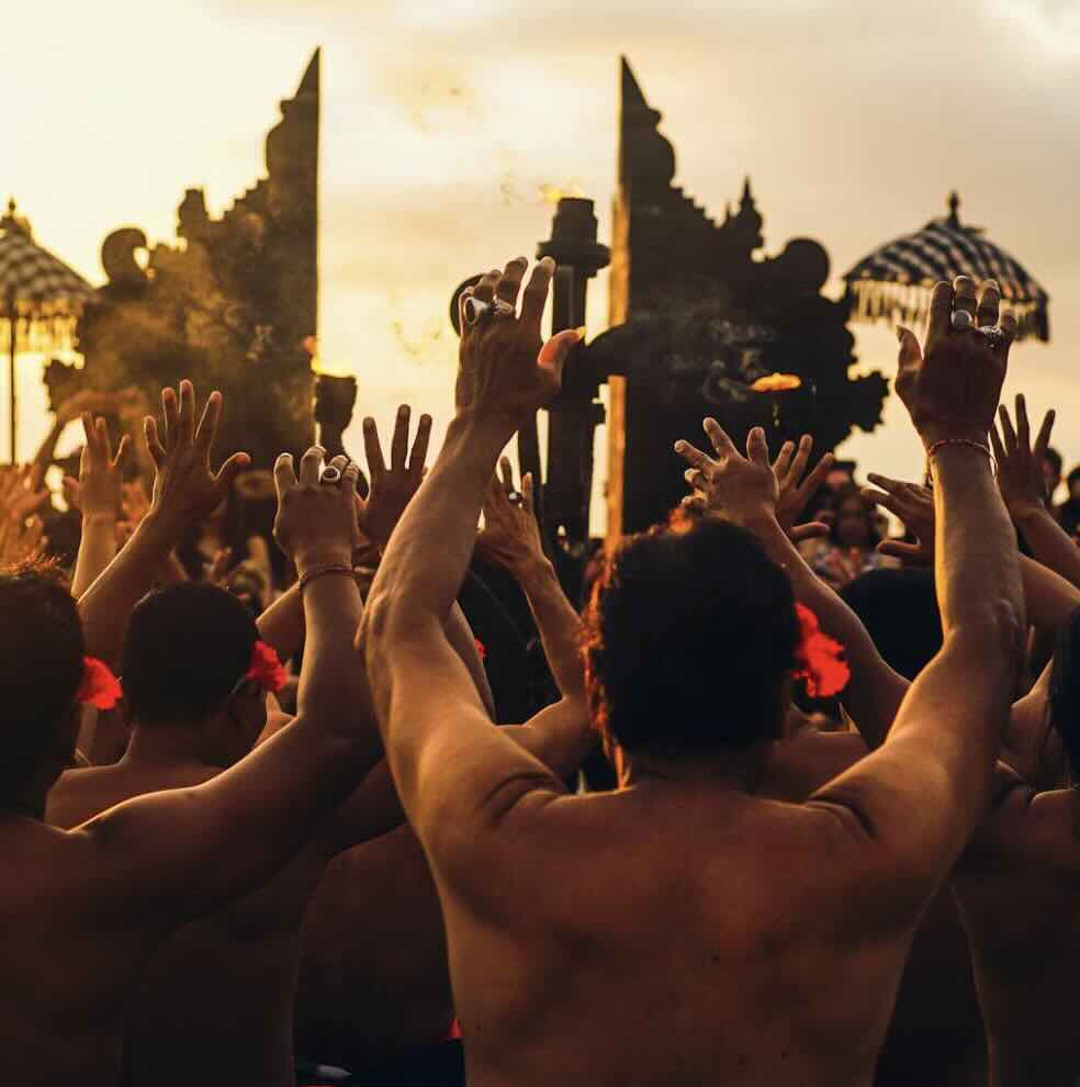 Kecak fire dance performers at sunset near Uluwatu Temple in Bali