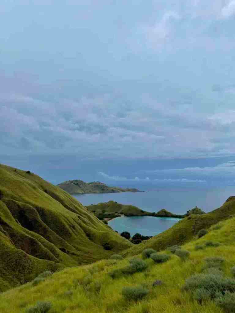 Green island hills and blue water views in Komodo National Park, Indonesia