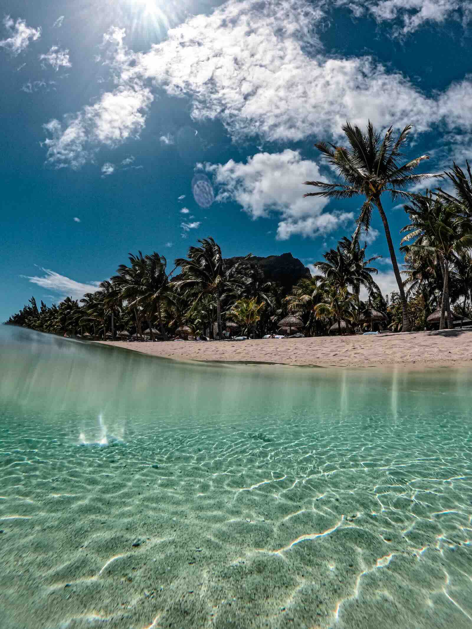 Crystal-clear turquoise lagoon and white sand at Le Morne Beach in Mauritius.